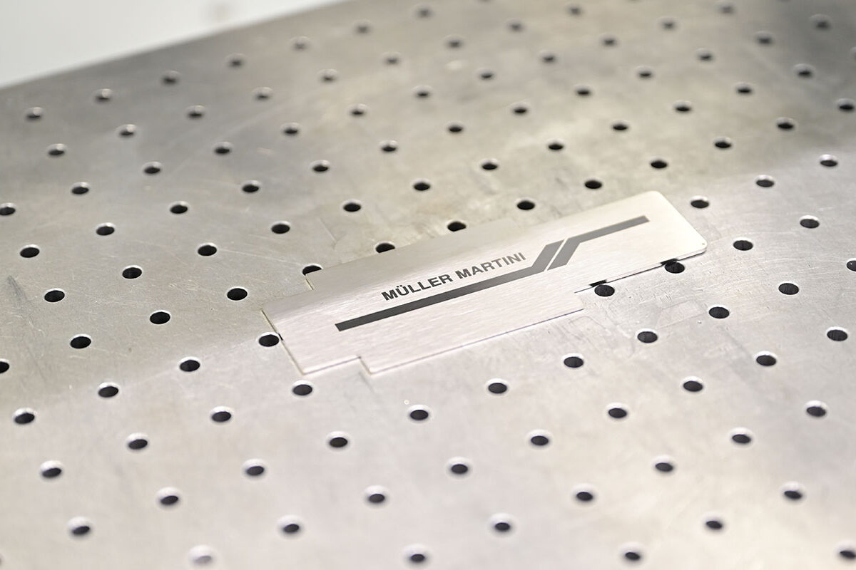 Gelasertes Müller Martini Manufacturing Logo.