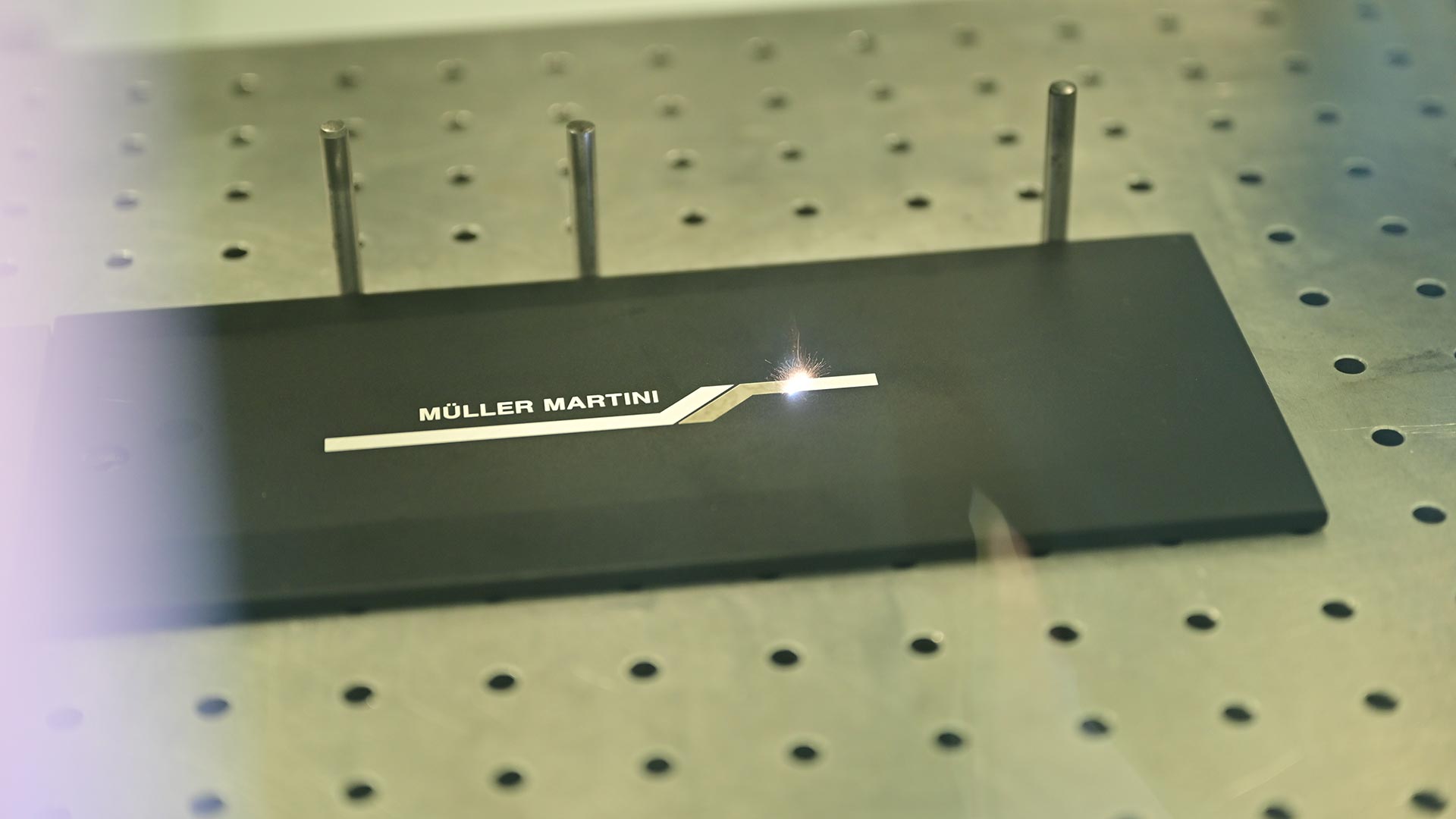 Beschriftungstechnik gelasertes Müller Martini Logo.